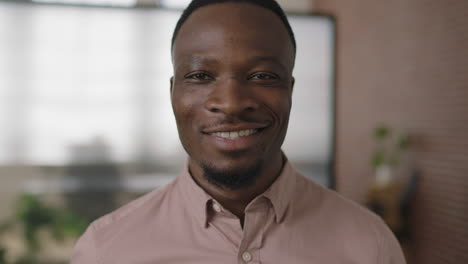 close up portrait of young african american businessman smiling enjoying successful start up business confident entrepreneur in modern office workspace