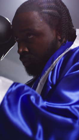 Vertical-Video-Of-Male-Boxer-Wearing-Gloves-And-Robe-Standing-In-Ring-For-Boxing-Match-Sparring-And-Warming-Up-Before-Fight-1