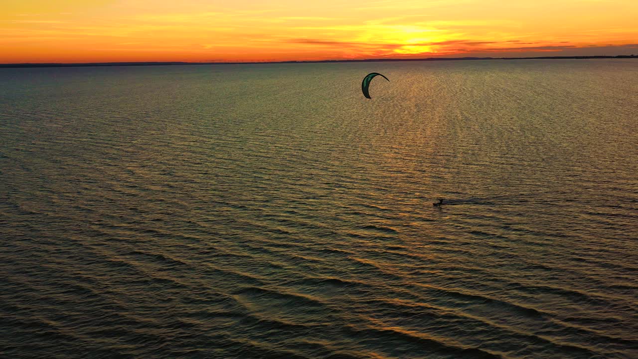 Aerial view. Kite surfing on the blue sea in the background of beautiful clouds. Sunset