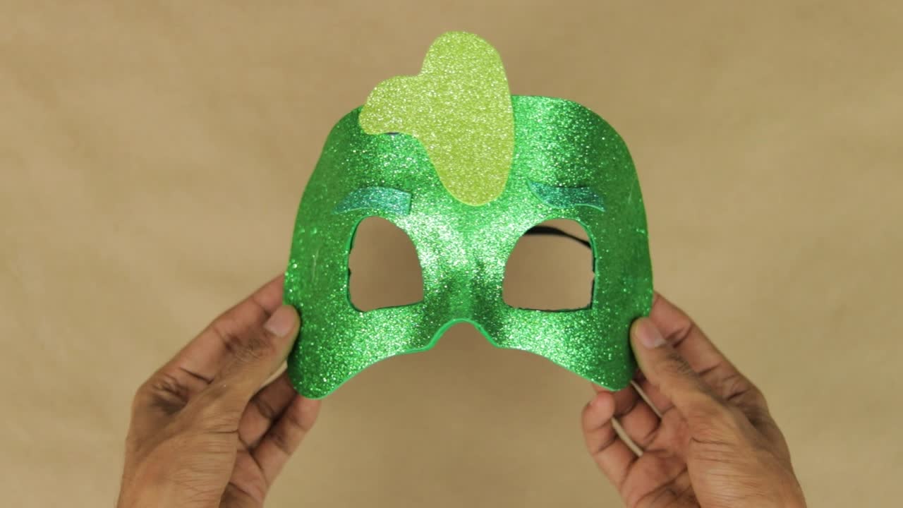 Mani che creano una maschera di schiuma verde brillante a forma di diamante ispirata al personaggio Gekko di PJ Masks