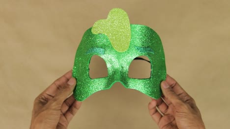 Hands-crafting-shiny-green-foam-diamond-mask-inspired-by-PJ-Masks-character-Gekko