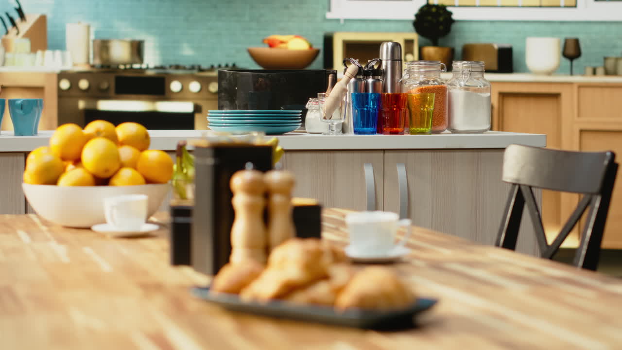 Empty wooden table with fruits and pastry served for breakfast in the kitchen