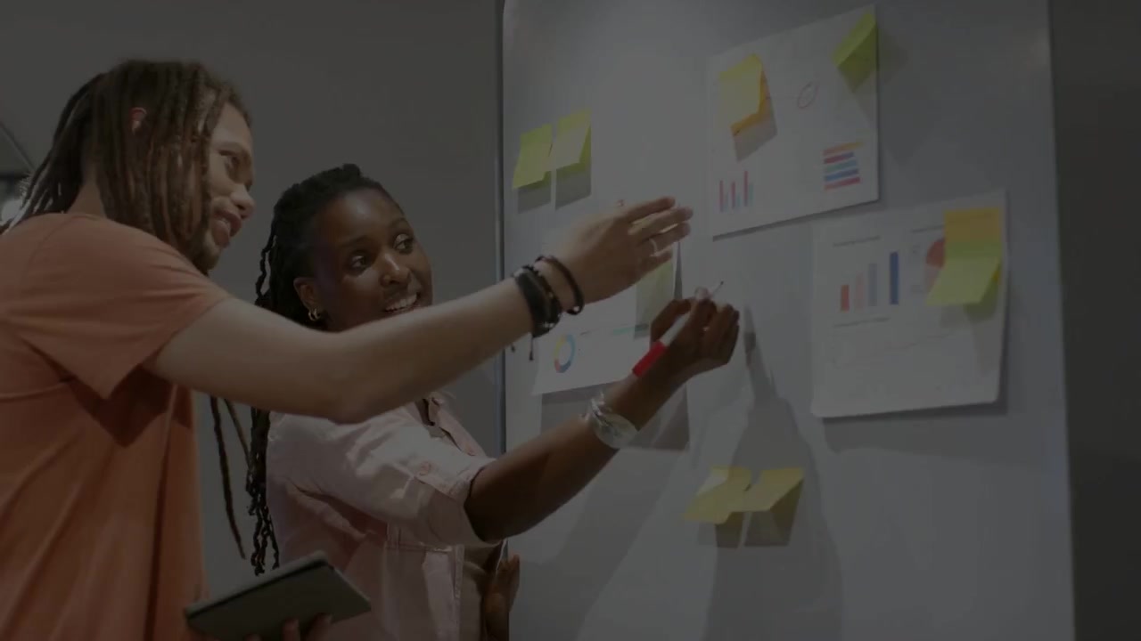 Woman raising red marker, man holding tablet pointing, writing and moving sticky notes for business