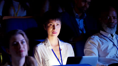 mujer de negocios asiática sentada con una computadora portátil en un seminario de negocios en el auditorio 4k