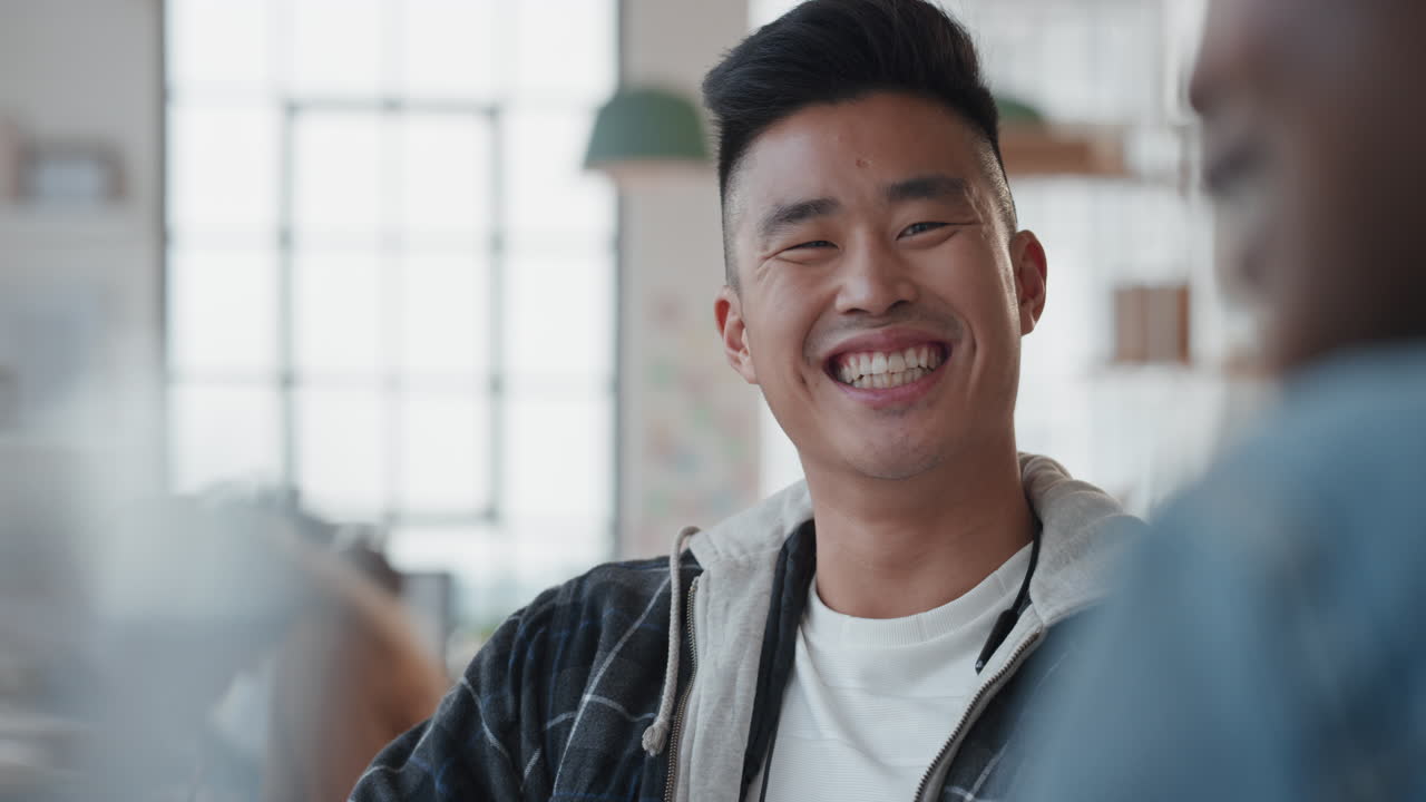 매력적인 젊은 아시아 남자 훈련 동료 웃고 대화를 나누고 아이디어를 공유하고 직장에서 창의적인 팀워크를 즐기고