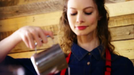 waitress pouring milk in coffee at counter