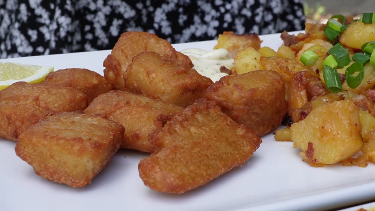 agregando sal y limón a los trozos de pescado frito