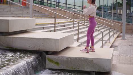 woman exercising outdoors on stairs near a fountain