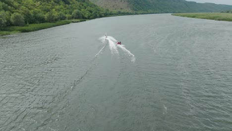 sports riding on a water bike on a river that leads two extreme vacationers