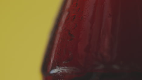 Close-Up-Of-Condensation-Droplets-Running-Down-Bottle-Of-Cold-Beer-Or-Soft-Drink-Against-Yellow-Background