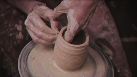 the potter makes a jug of clay. vintage effect. a man makes a vase on a potter's wheel