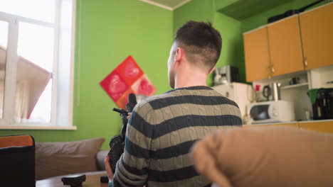 man working with camera lens, setting up filming equipment on desk in home studio, preparing for video production in modern, well-lit indoor environment