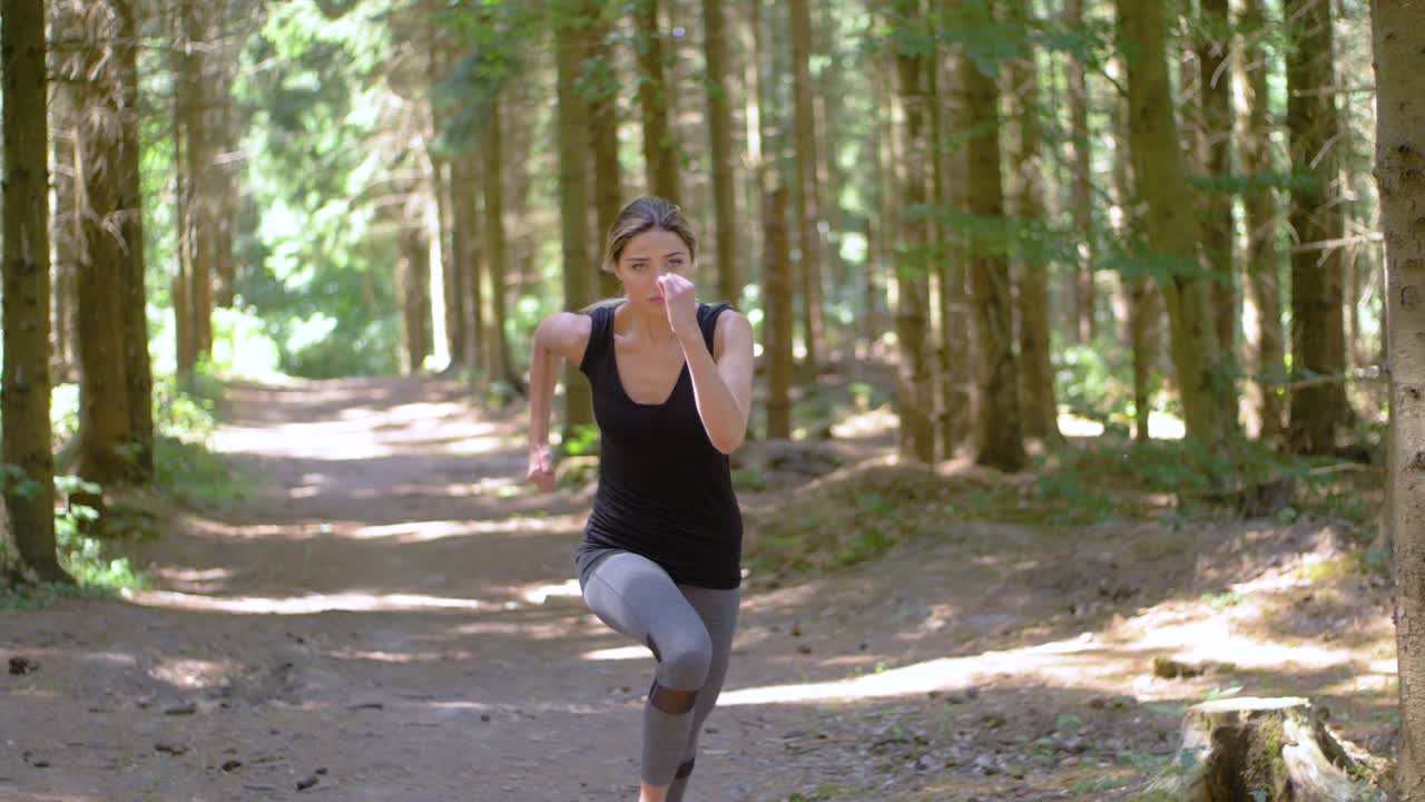 Una giovane donna atletica e in forma inizia uno sprint su un sentiero in un parco