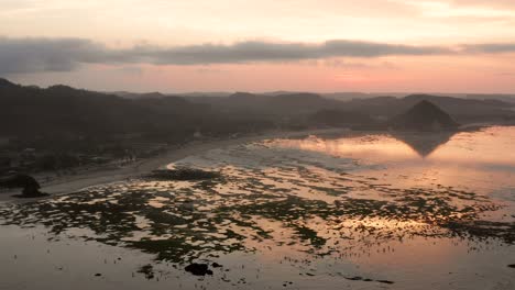 The-dry-reef-of-Kuta-Lombok-during-sunrise,-with-local-people-looking-for-food-and-seashells