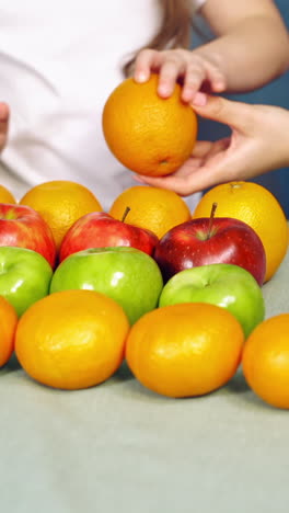 little girl with fruits on table. close up view of girl with fruits on table