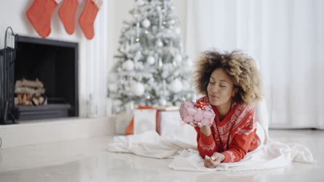 Junge-Afrikanische-Mädchen-Liegend-Blick-Auf-Ihr-Weihnachtsgeschenk