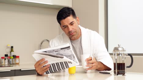 Handsome-man-drinking-coffee-and-reading-newspaper