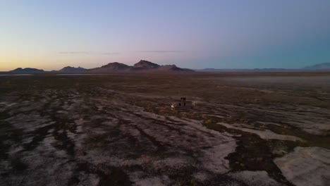 herd of horses on the desert winter landscape at sunset with rugged mountains in the background - aerial view