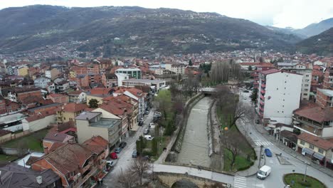 Vista-Superior-Del-Río-Pena-Pasando-Por-La-Ciudad-De-Tetovo,-Ciudad-Balcánica-Con-Vehículos-Pasando-Por-Sus-Calles-Y-Carreteras