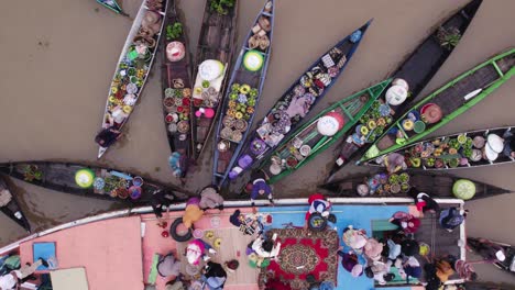 colorido mercado flotante con gente local intercambiando alimentos en el agua, de arriba hacia abajo