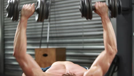 hombre en forma sin camisa levantando pesas