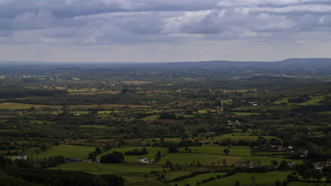 Zeitraffer-Von-Verschwommenem-Gras-Im-Vordergrund-Und-Ländlichem-Ackerland-In-Der-Ferne-Während-Eines-Bewölkten,-Sonnigen-Tages,-Gesehen-Von-Oben-über-Dem-Lough-Meelagh-In-Der-Grafschaft-Roscommon-In-Irland