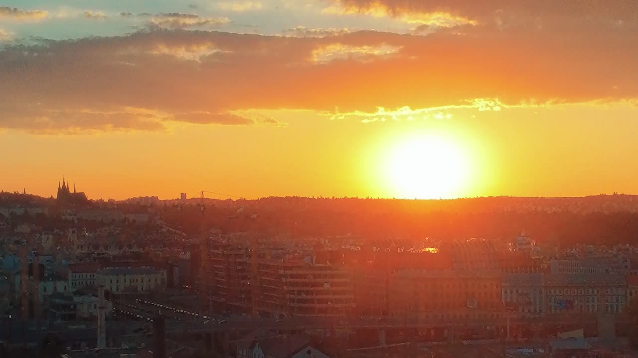 Voo de drone sobre o horizonte de Praga ao pôr do sol com o Castelo de Praga.