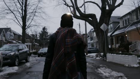 a woman with a scarf walking on the snowy streets of toronto on a late afternoon - close up shot