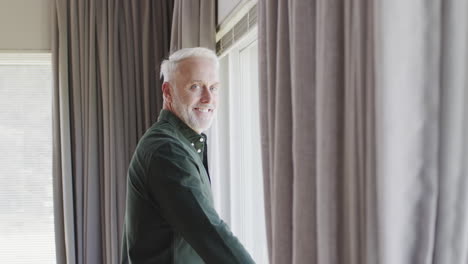 portrait of middle aged happy caucasian man by window at home with copy space