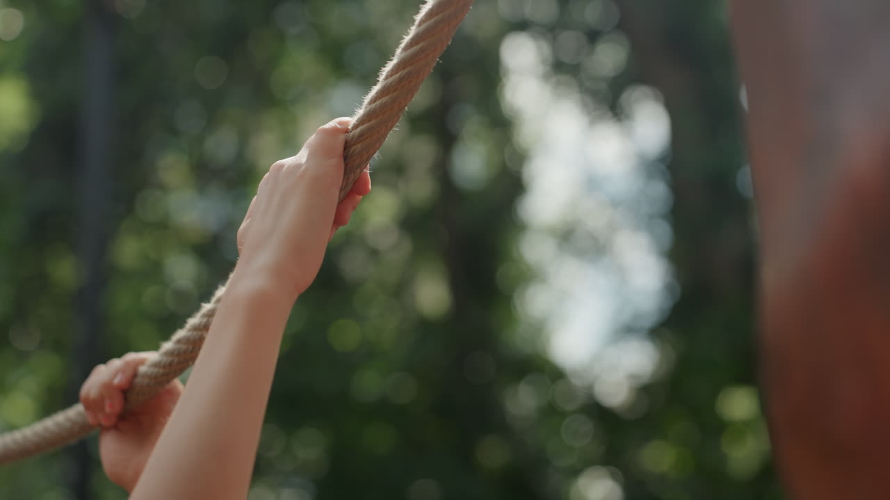 Child pulls rope. Child exerts force pulling thick rope outside calmly and firmly. Young girl concentrates intensely on tugging strong textured rope outdoors with determination and composure