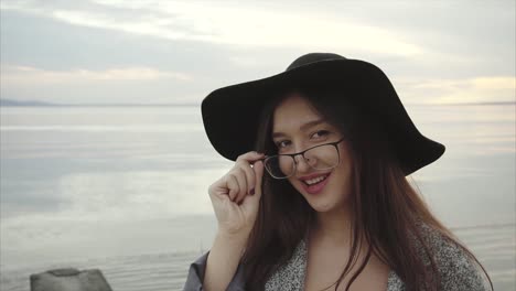 woman in a black hat by the lake