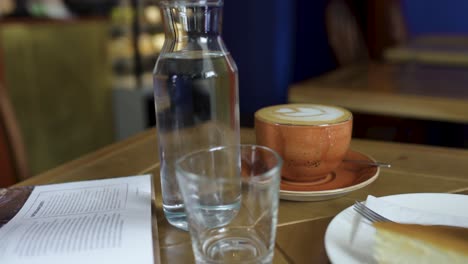 escena de café con café con leche, agua y postre