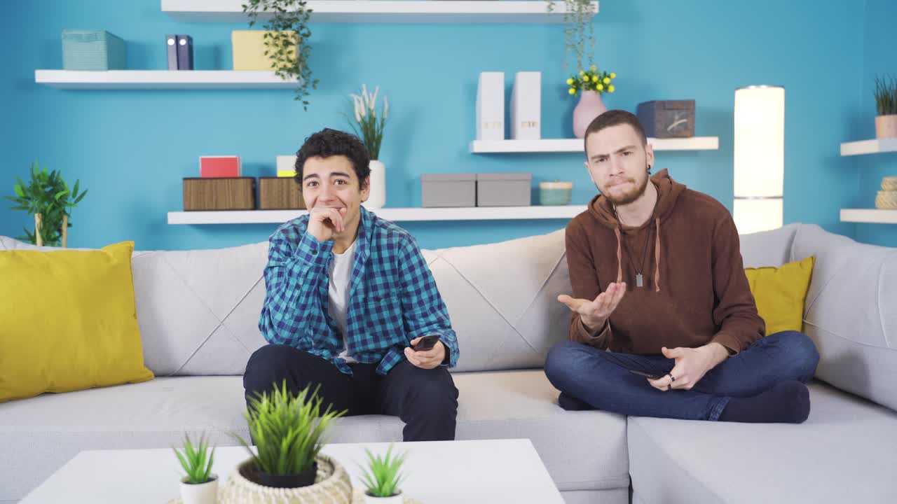 tv를 보고 큰 소리로 웃고 있는 남동생은 큰 동생으로부터 경고를 받습니다.