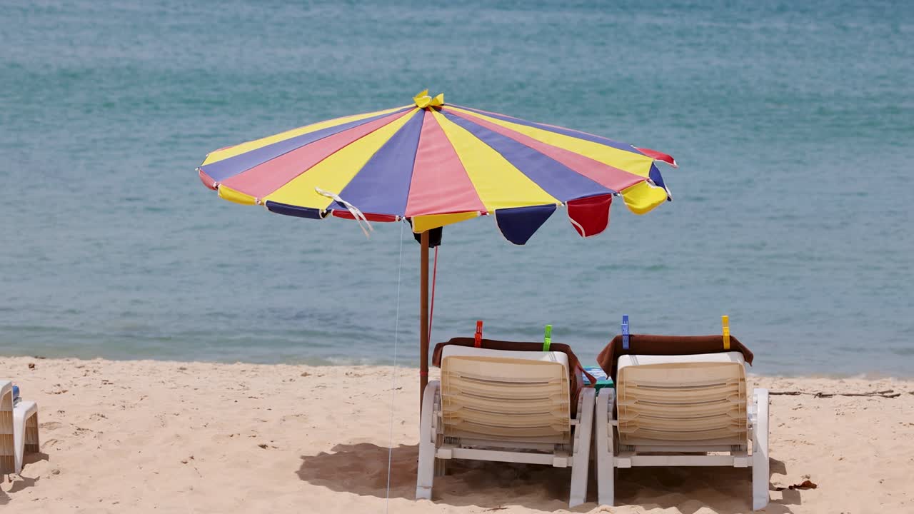 una vista serena de la playa con sombrillas y sillas de colores, capturando la esencia tranquila de la costa de phuket