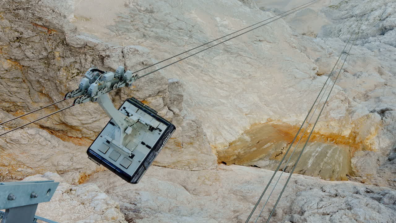 A panoramic perspective of a chairlift en route to its designated station traversing the majestic mountain range