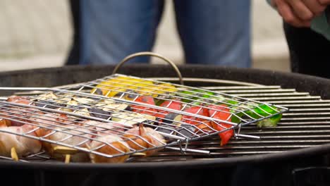 grilled vegetables and bacon wrapped sausages on skewers