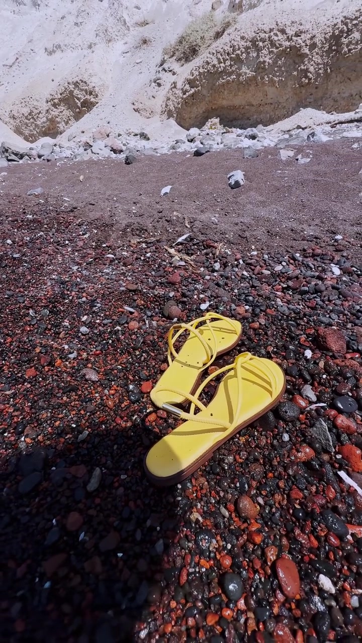 Gule sandaler på den berømte røde strand på Santorini, Grækenland