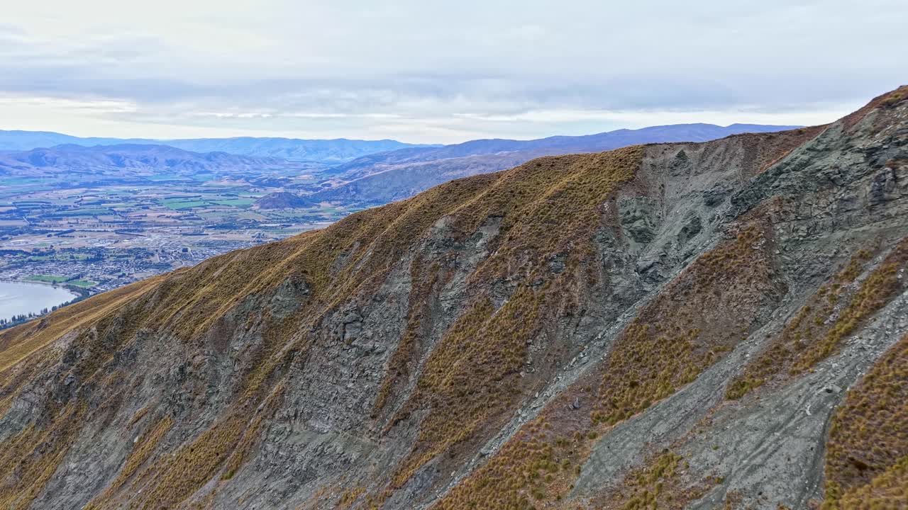 Drone advances along Roys Peak slope before revealing valley below in Otago