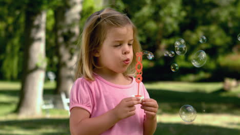 Kleines-Mädchen-Spielt-Mit-Seifenblasen-Im-Park