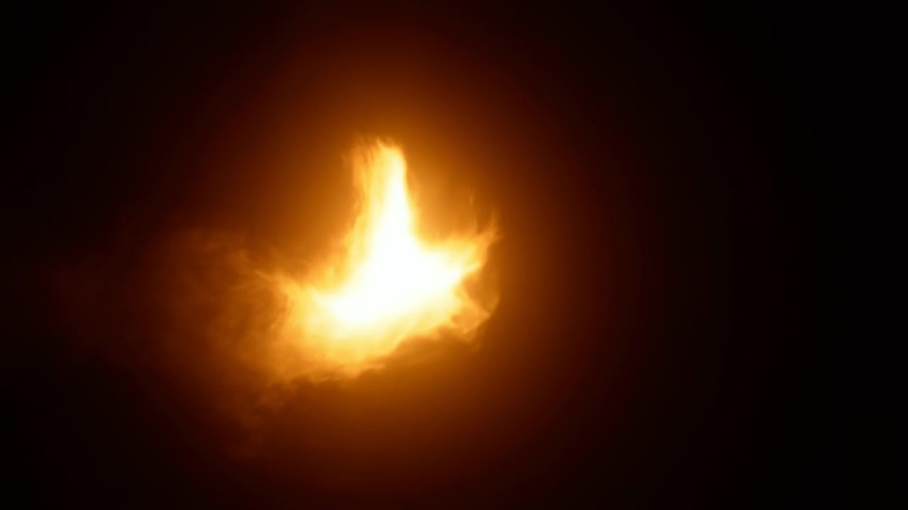 Bright orange yellow flame rises from dark space with dense glowing core, widening smoke plume, soft haze, vivid contrast, and strong sense of heat, movement, danger, and luminous energy
