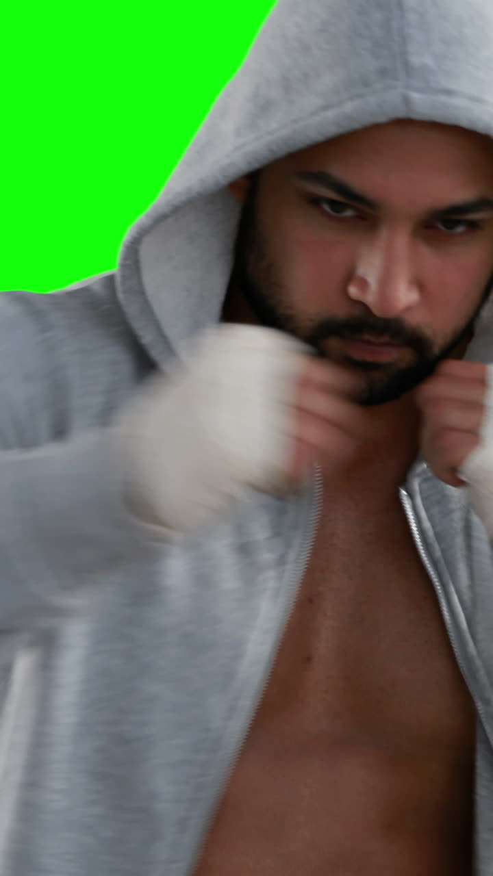 мускулистый мужчина в сером капюшоне