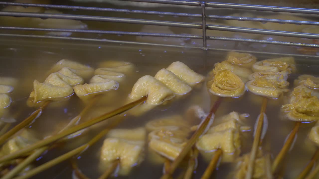 Oden coréen blanc nature non épicé sur des brochettes en bois bouillant dans une soupe salée.