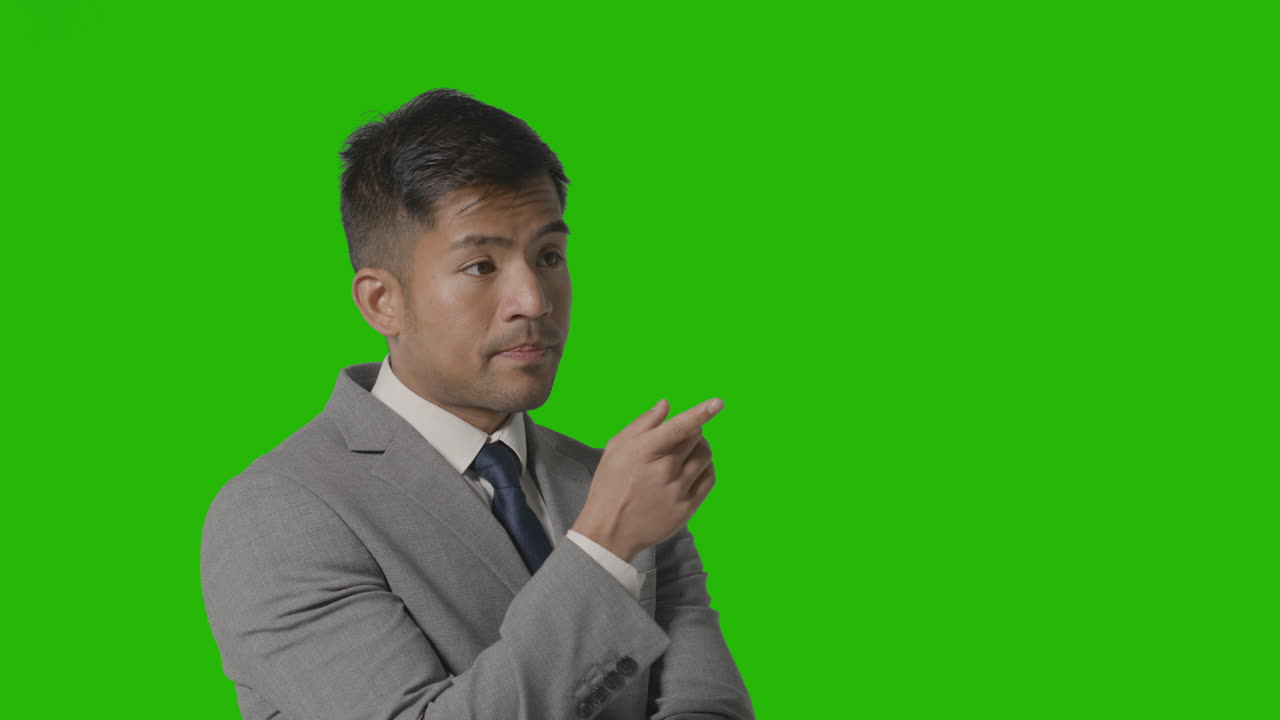 Portrait Of Serious Businessman In Suit Thinking Against Green Screen 
