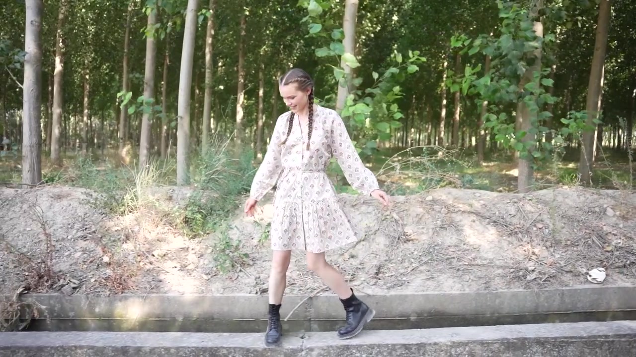 Una giovane donna si gode una passeggiata lungo un bellissimo sentiero lussureggiante nel bosco, circondata dalla natura.
