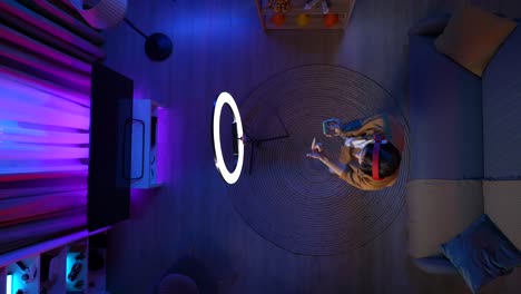 person streaming in a room at night with ring light