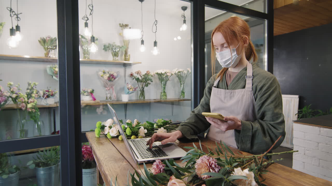 Giovane fiorista con smartphone al lavoro