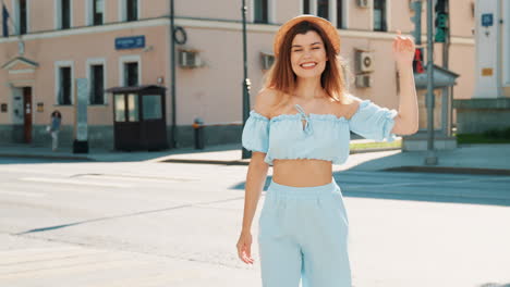 smiling woman in light blue outfit on city street