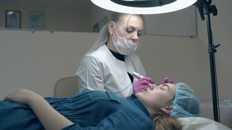 cosmetician emocionante aplica maquillaje permanente en el salón