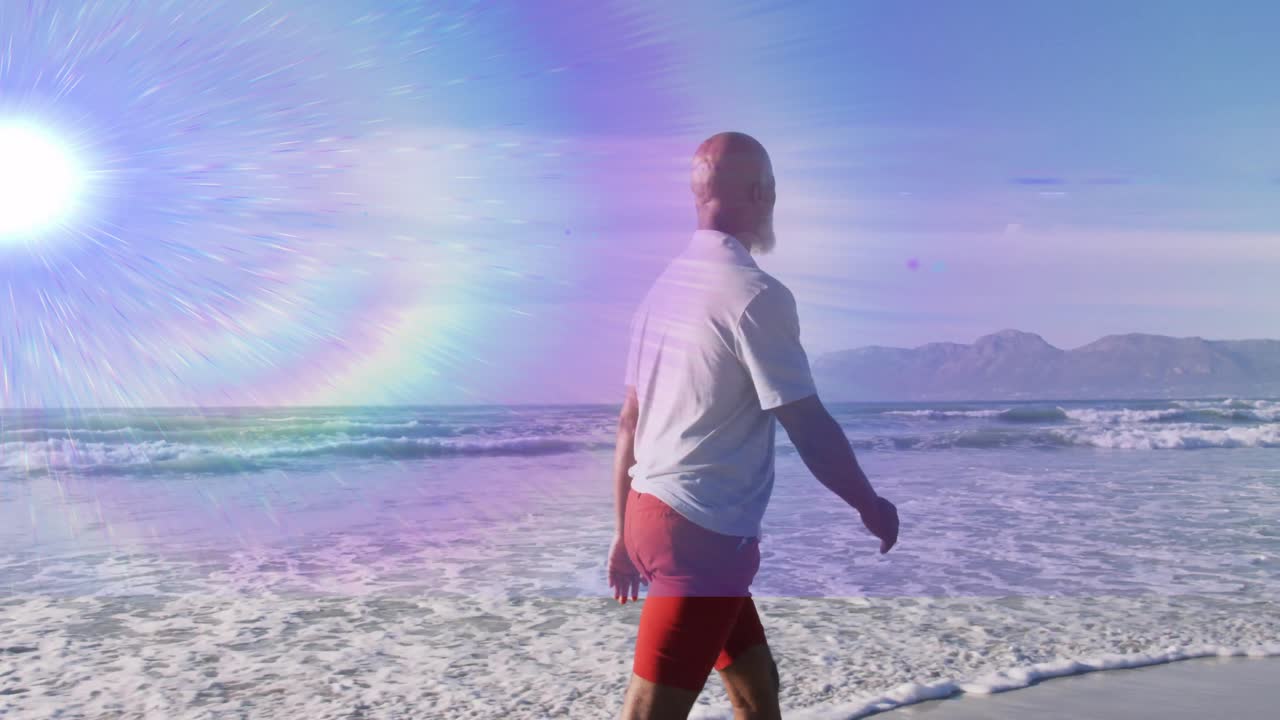 Man komt in beeld en wandelt langs de kustlijn met golven onder regenbooglensflare, wat gezondheid stimuleert.