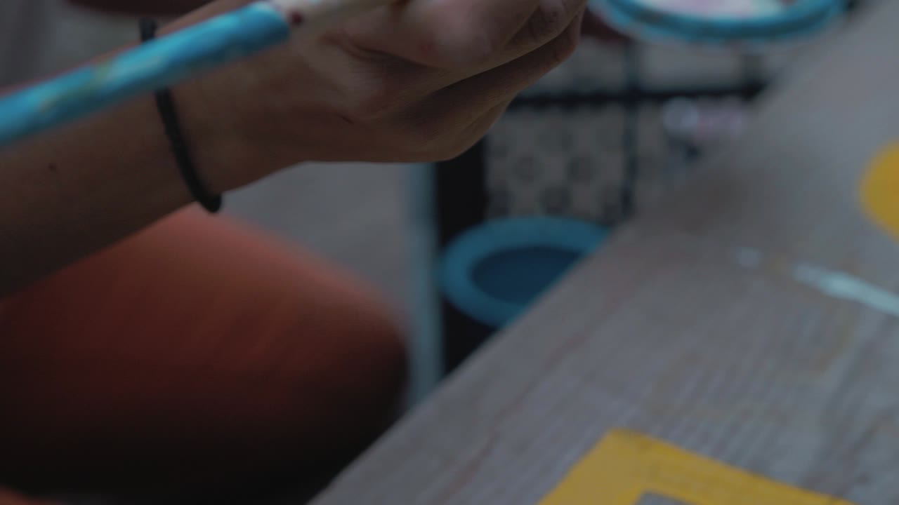 Taking paint brush and painting letters on sign